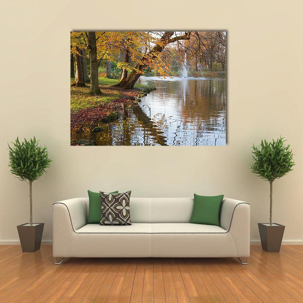 Beech Trees by Pond Canvas Wall Art in brown, orange and green, single panel hung on a wall