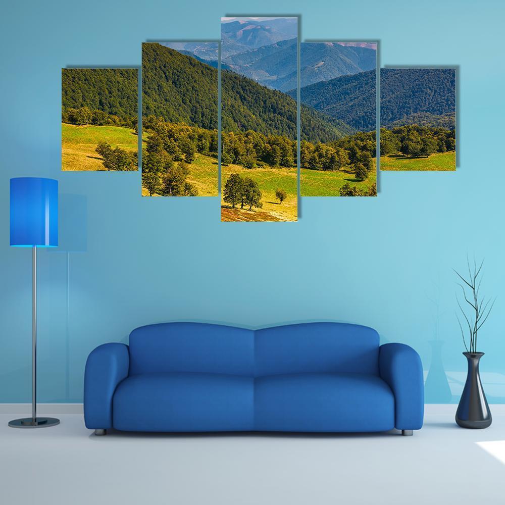 Beech Trees on Rolling Hills Canvas Wall Art in yellow, green and blue, 5 panel Star layout hung on a wall