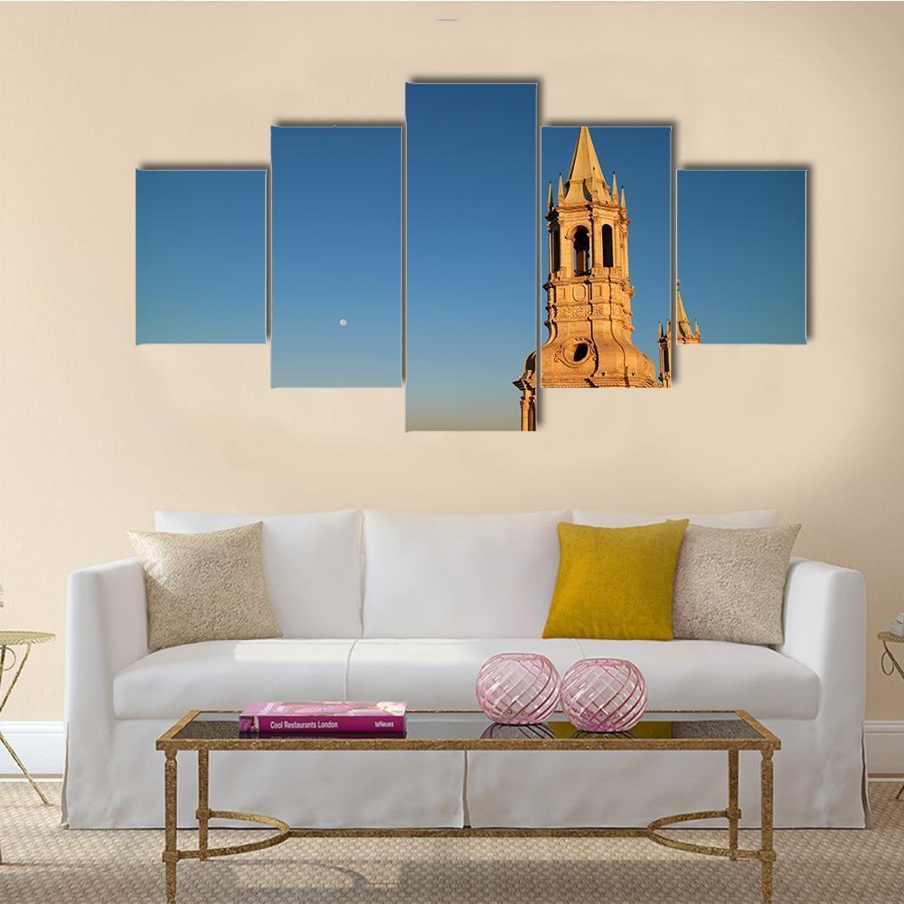 Bell Tower with Moon at Sunset Canvas Wall Art in beige, gold and blue, 5 panel Star layout hung on a wall