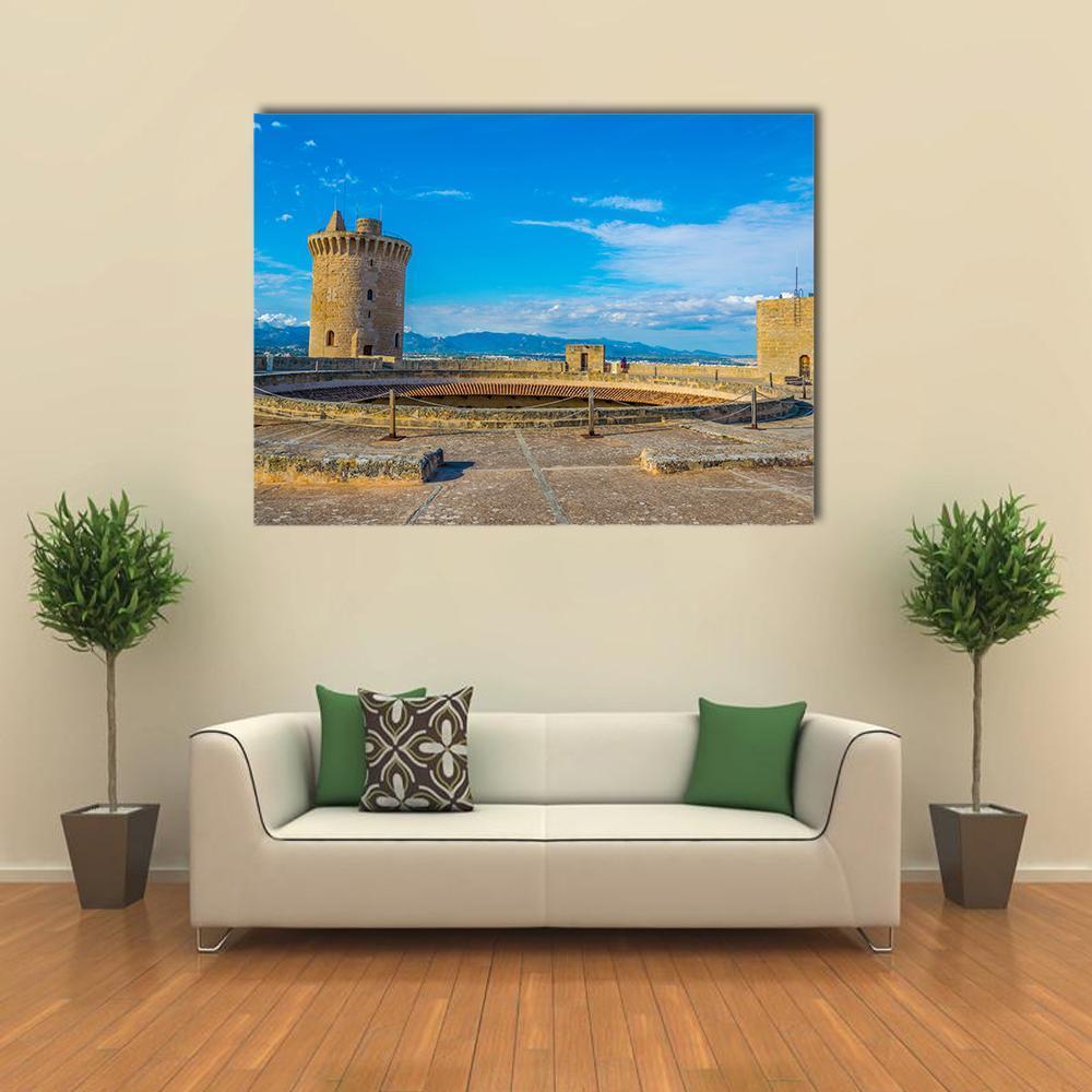 Bellver Castle Stone Fortress Over Mountains Canvas Wall Art in beige, brown and blue, single panel hung on a wall