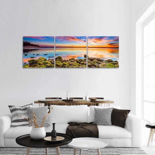Benbrook Lake Sunset with Mossy Rocks Panoramic Canvas Wall Art in orange, green and blue, hung on a wall