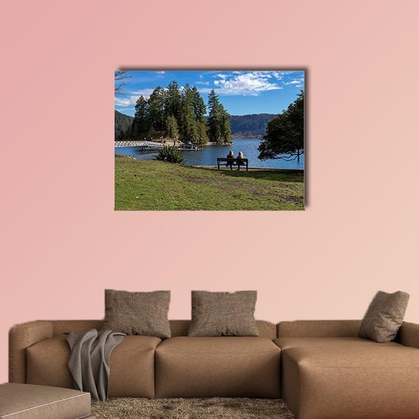 Pier Over Lake with Island and Bench Canvas Wall Art in brown, green and blue, single panel hung on a wall