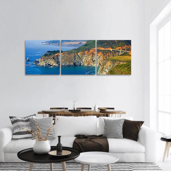 Big Sur Coastal Cliffs with Bridge Panoramic Canvas Wall Art in brown, green and blue, hung on a wall
