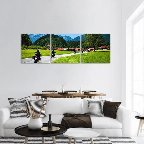 Motorcyclists on Alpine Road Panoramic Canvas Wall Art in gray, green and blue, hung on a wall
