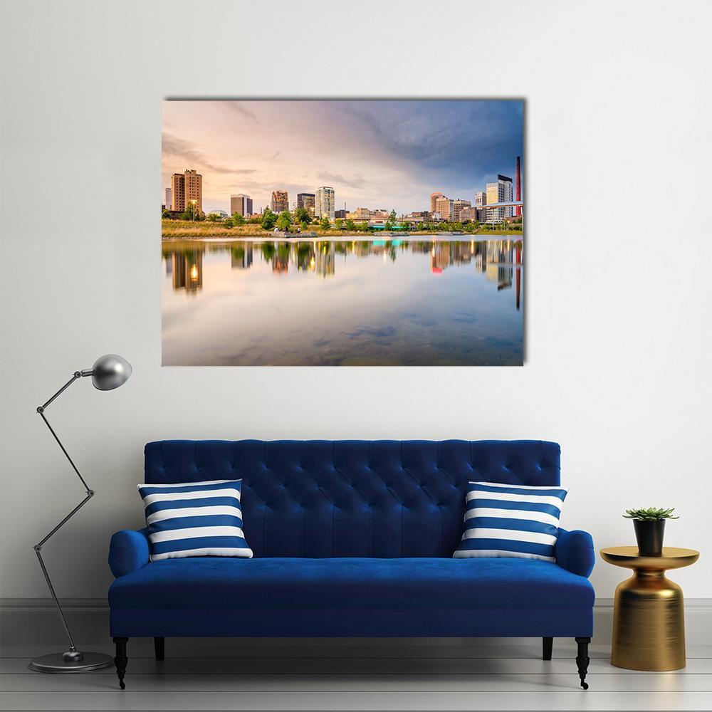 City Skyline at Sunset with Water Reflection Canvas Wall Art in orange, yellow and blue, single panel hung on a wall