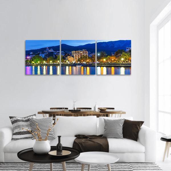 Yalta Night Waterfront with Mountain Silhouettes Panoramic Canvas Wall Art in black, yellow and blue, hung on a wall