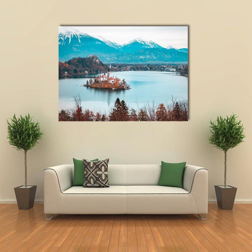 Island Church on Lake with Mountain Backdrop Canvas Wall Art in white, brown and blue, single panel hung on a wall
