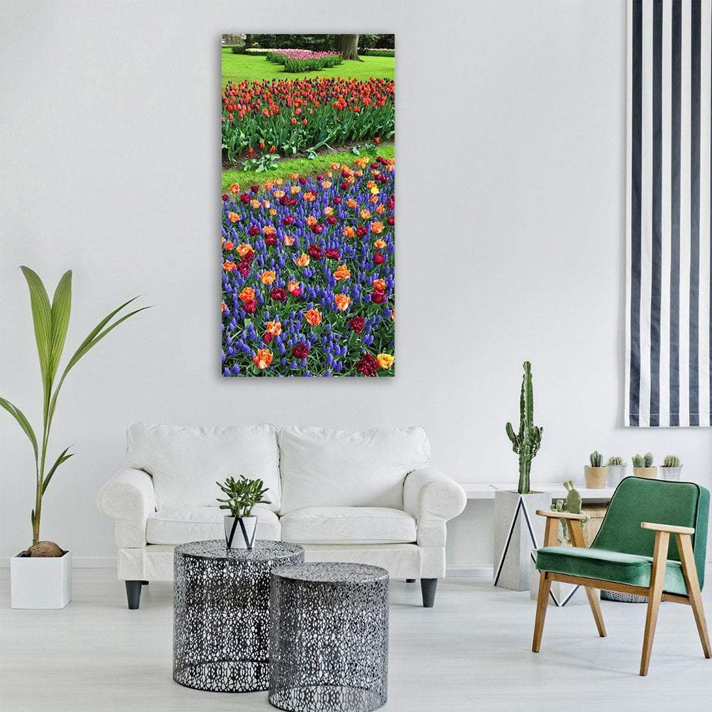 Layered Tulips and Grape Hyacinths Vertical Canvas Wall Art in green, purple and multicolor, single vertical panel hung on a wall
