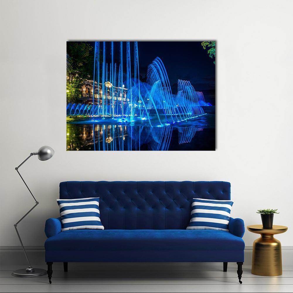 Vibrant Blue Fountains at Night Canvas Wall Art in black and blue, single panel hung on a wall
