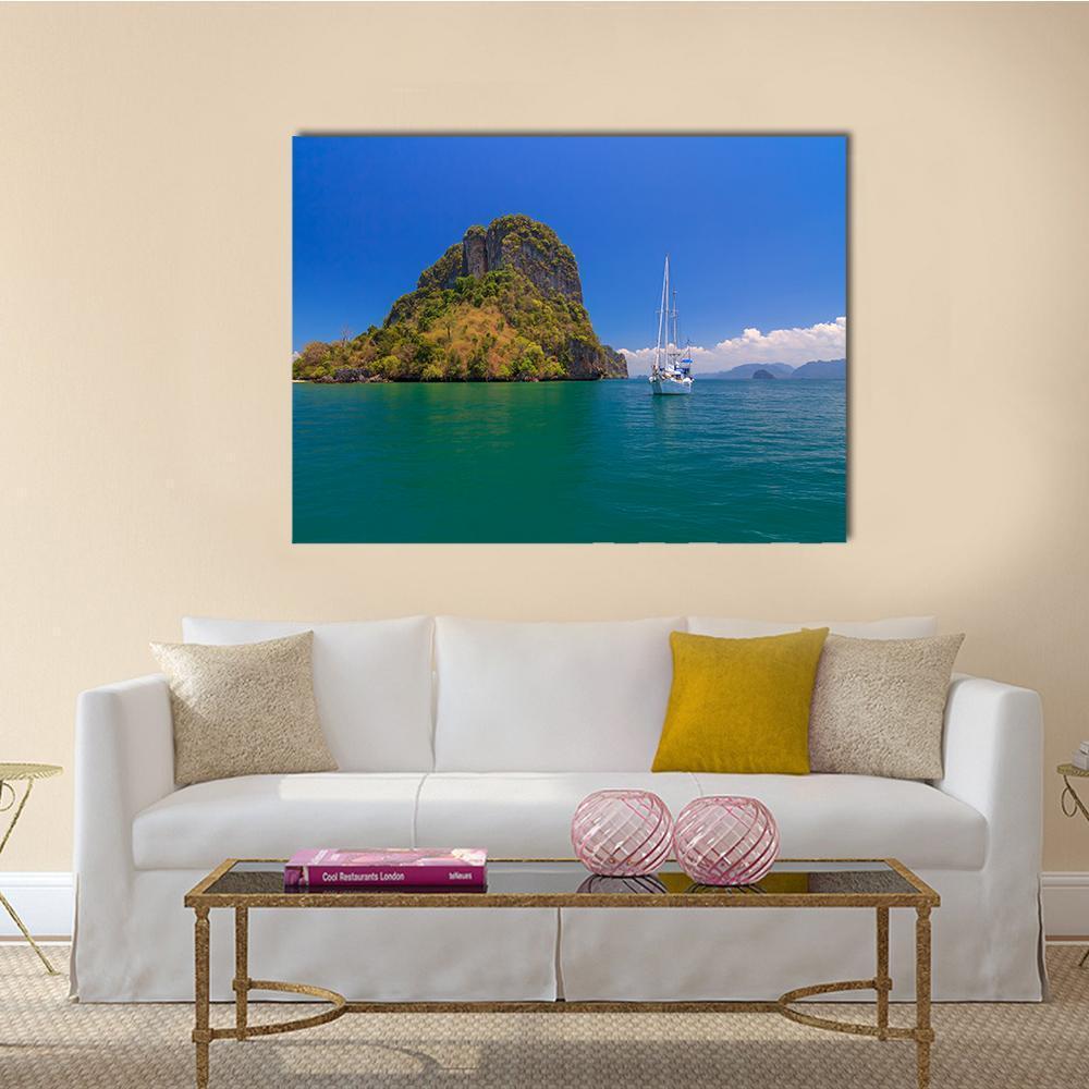 Blue Sea with Island and Sailboat Canvas Wall Art in green and blue, single panel hung on a wall