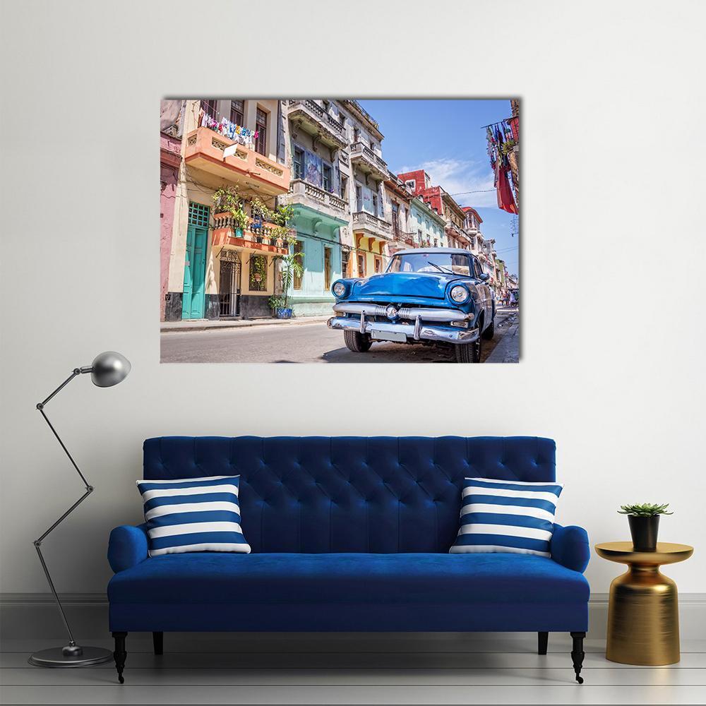 Blue Vintage Car on Cobblestone Street Canvas Wall Art in beige, blue and multicolor, single panel hung on a wall