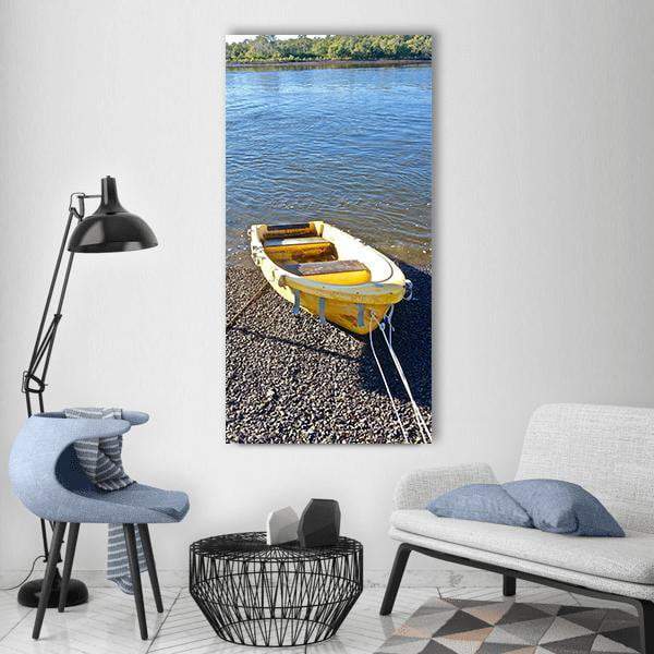 Yellow Rowboat on Pebble Shore Vertical Canvas Wall Art in gray, yellow and blue, single vertical panel hung on a wall
