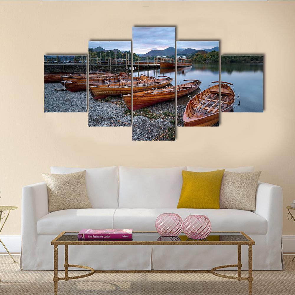 Wooden Rowboats on Pebble Shore at Dusk Canvas Wall Art in gray, brown and blue, 5 panel Star layout hung on a wall