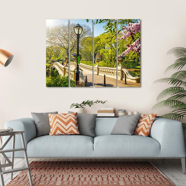 Bow Bridge in Central Park Canvas Wall Art in beige, green and blue, hung on a wall