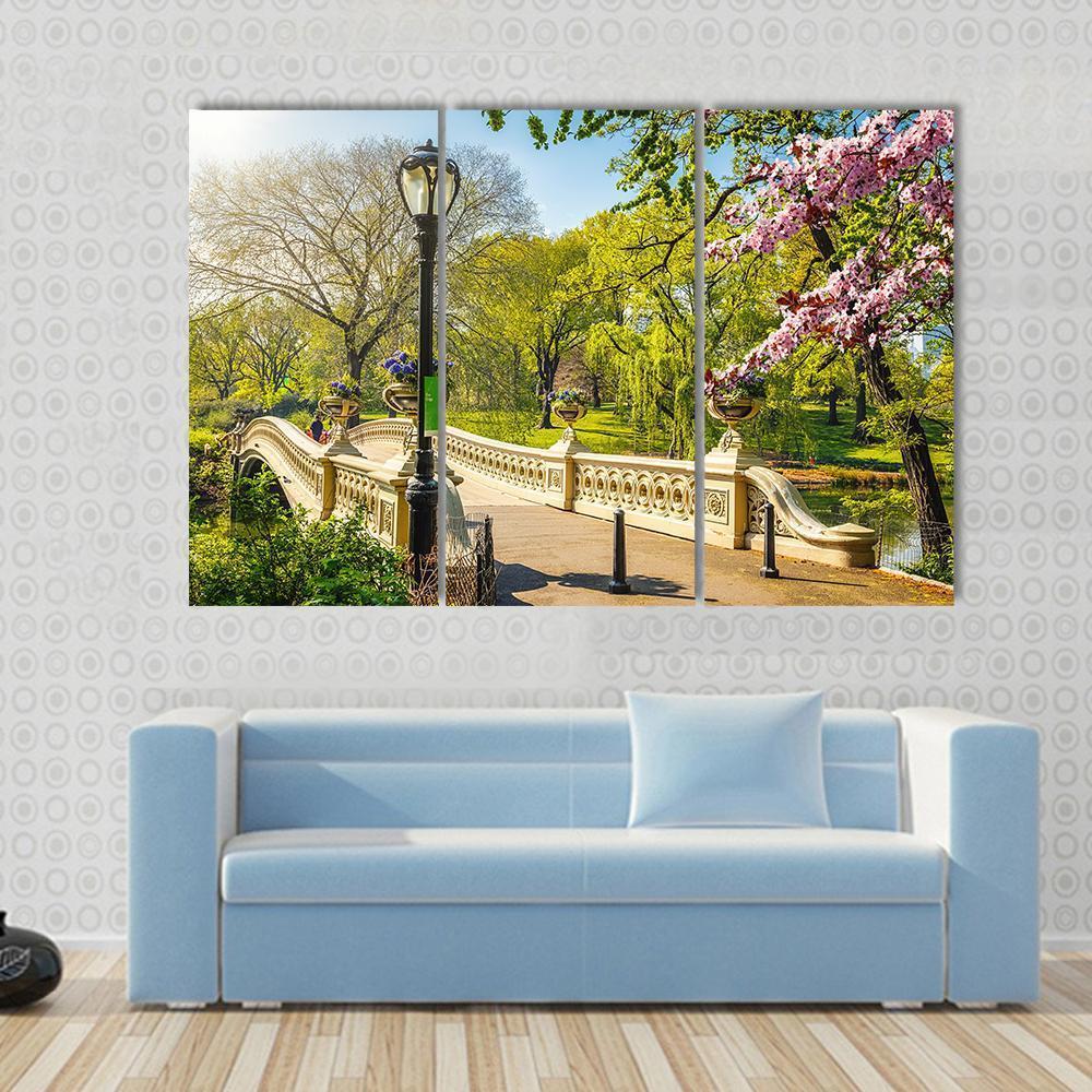 Bow Bridge in Central Park Canvas Wall Art in beige, green and blue, single panel hung on a wall