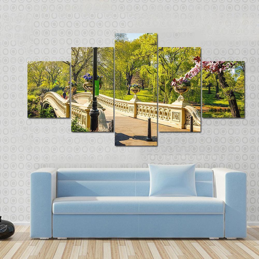Bow Bridge in Central Park Canvas Wall Art in beige, green and blue, single panel hung on a wall