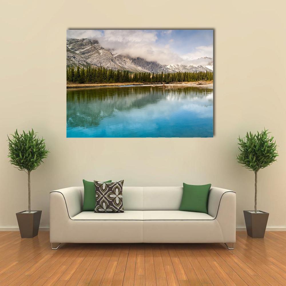 Snow-capped Mountain and River Reflection Canvas Wall Art in gray, green and blue, single panel hung on a wall