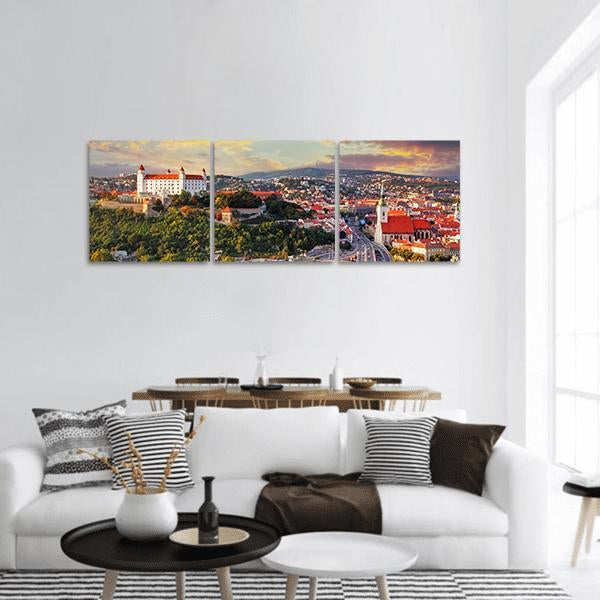 Bratislava Castle at Sunset Panoramic Canvas Wall Art in orange, yellow and green, hung on a wall