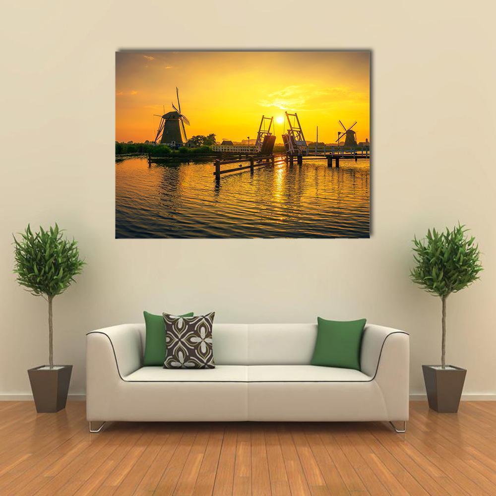 Wooden Drawbridge and Windmills at Sunset Canvas Wall Art in brown, orange and yellow, single panel hung on a wall