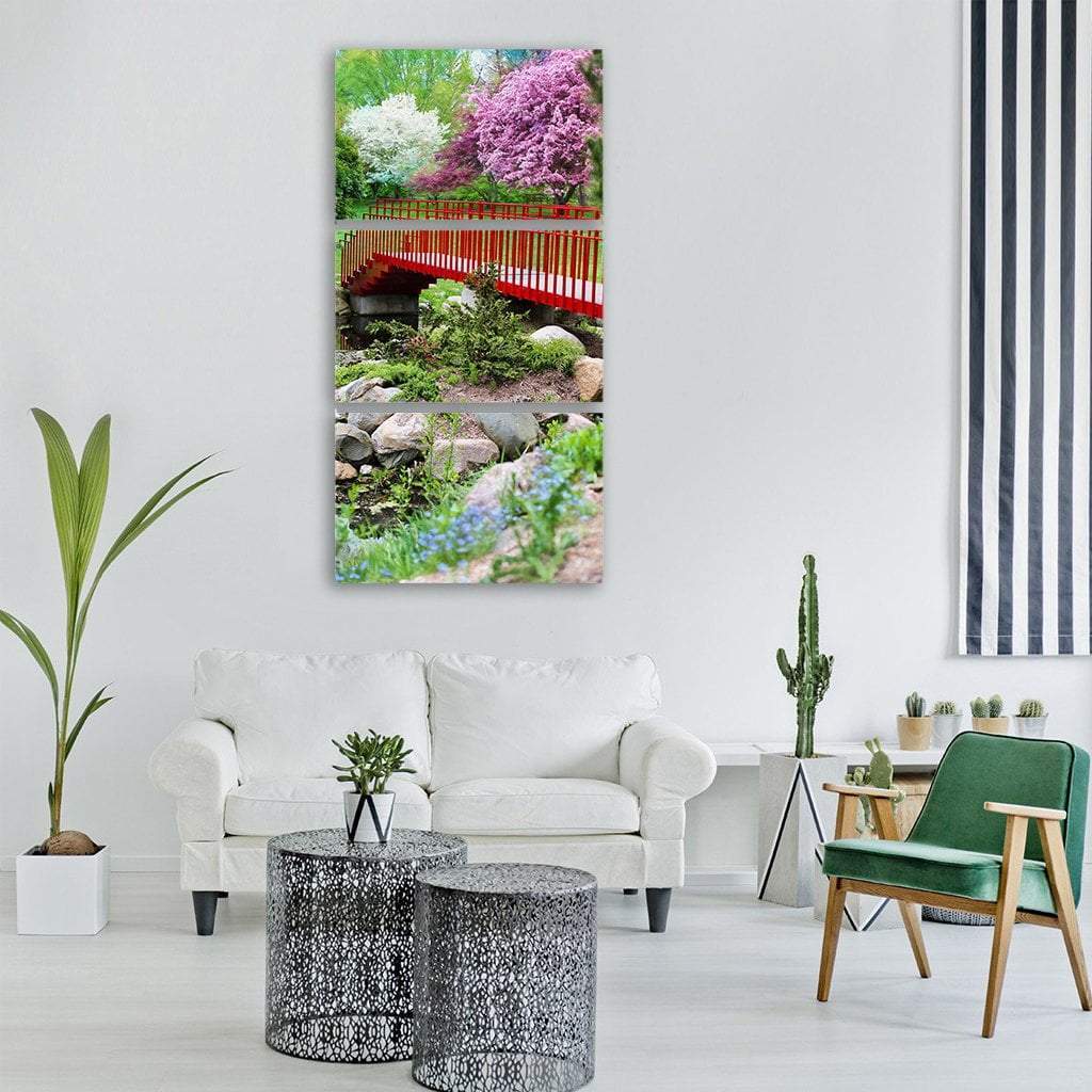 Red Bridge in Spring Garden Vertical Canvas Wall Art in red, green and pink, hung on a wall
