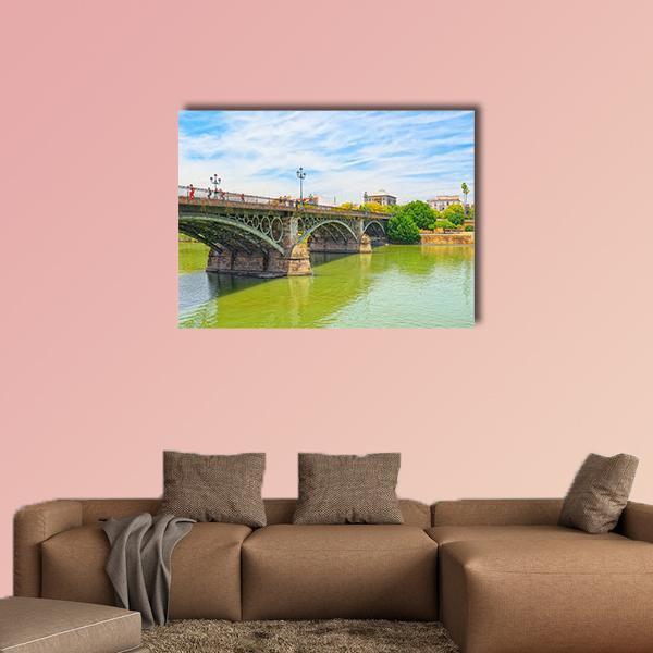 Bridge of Isabel Ii Canvas Wall Art in brown, green and blue, single panel hung on a wall