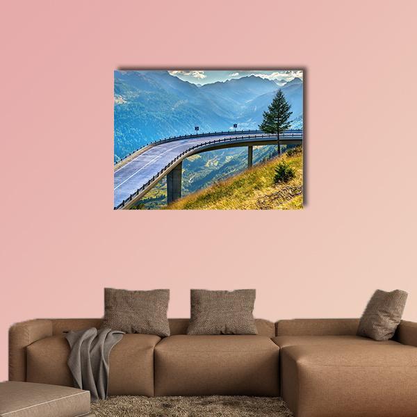 Gotthard Pass Bridge Over Curving Mountain Road Canvas Wall Art in gray, green and blue, single panel hung on a wall