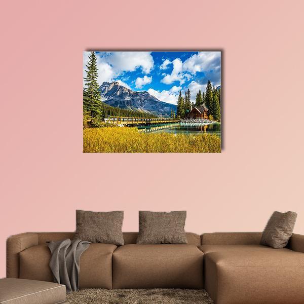Wooden Bridge Over Emerald Lake Canvas Wall Art in yellow, green and blue, single panel hung on a wall
