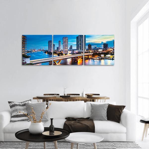 Bridge Over Phraya River Panoramic Canvas Wall Art in orange, yellow and blue, hung on a wall