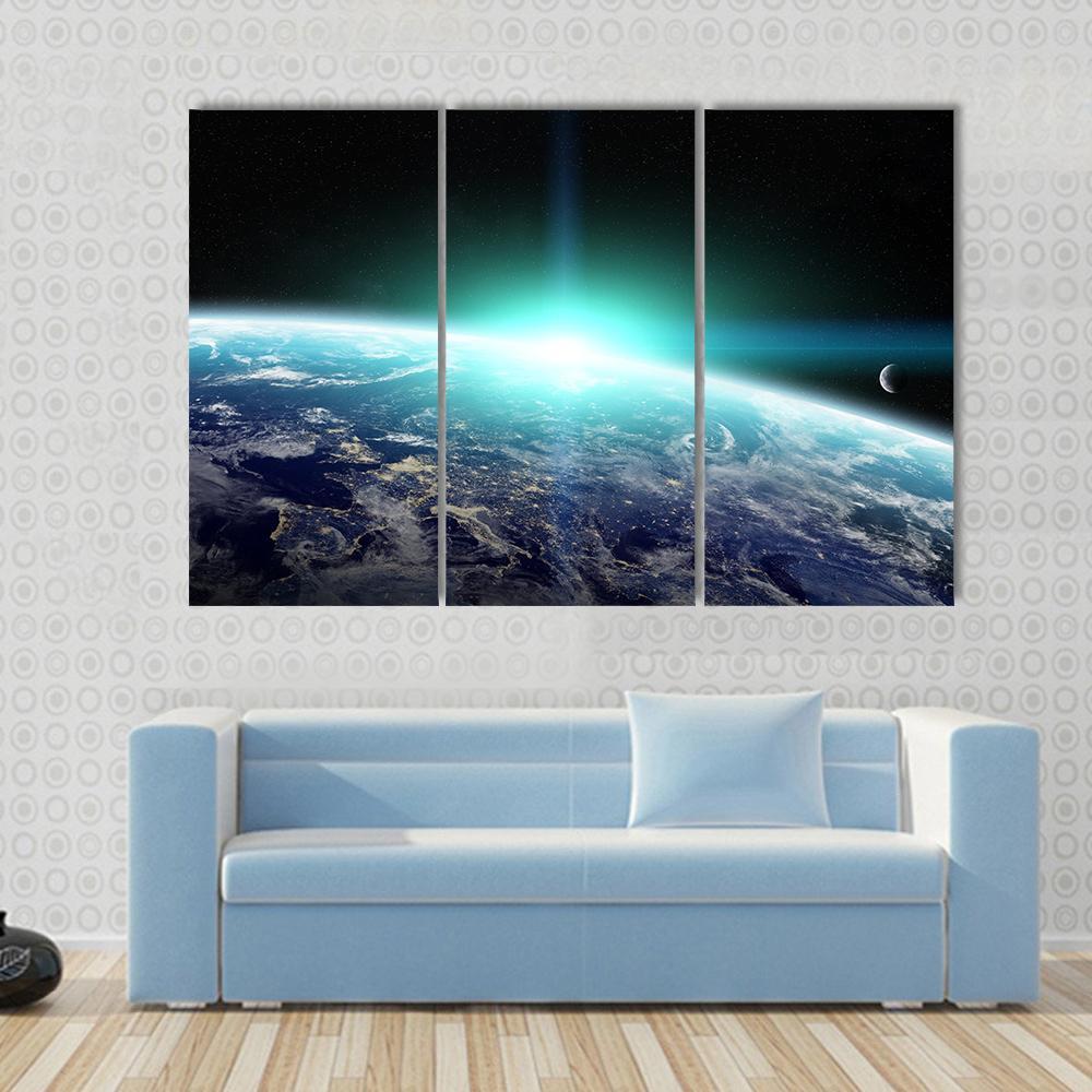 Bright Sun Over Planet Earth Canvas Wall Art in black, white and blue, 3 panel horizontal set hung on a wall