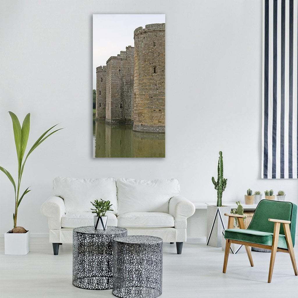Medieval Castle Towers Over Green Moat Vertical Canvas Wall Art in gray, beige and green, single vertical panel hung on a wall