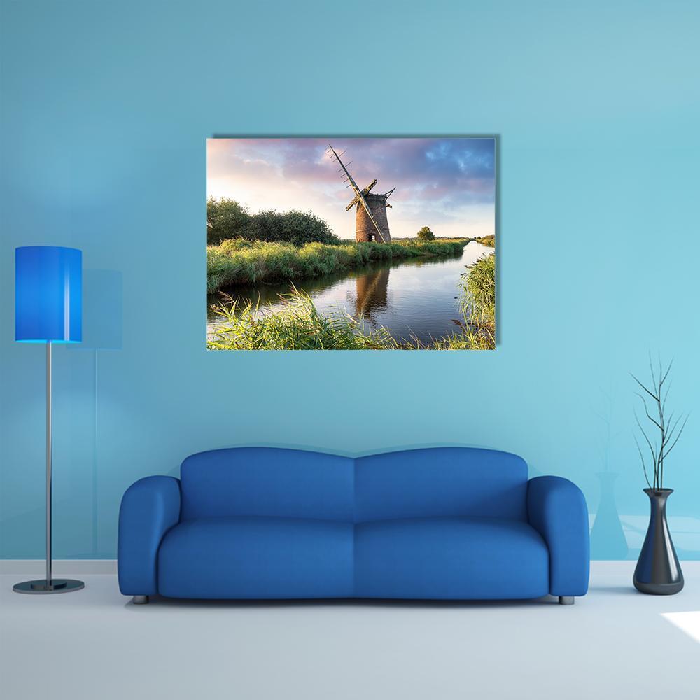 Brograve Windmill at Sunset Canvas Wall Art in orange, green and blue, single panel hung on a wall