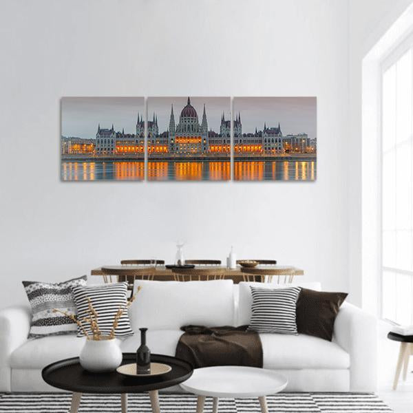 Budapest Parliament at Dusk Panoramic Canvas Wall Art in gray, orange and blue, hung on a wall