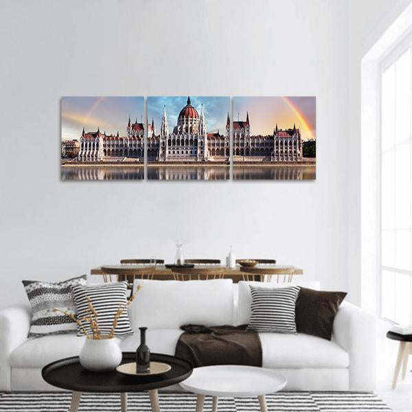 Budapest Parliament with Double Rainbow Reflection Panoramic Canvas Wall Art in white, orange and blue, hung on a wall