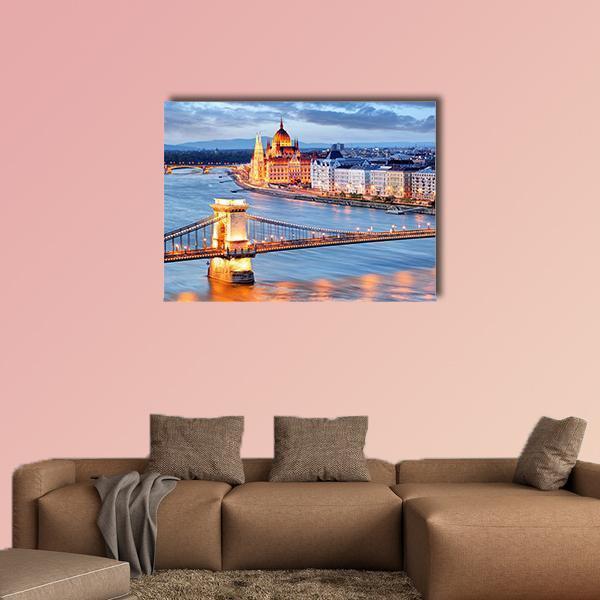 Budapest Chain Bridge at Dusk Canvas Wall Art in orange, yellow and blue, single panel hung on a wall