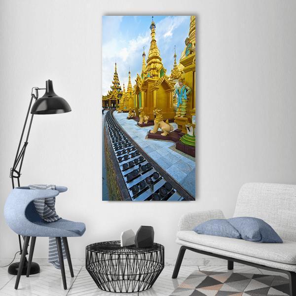 Golden Buddhist Pagodas of Myanmar Vertical Canvas Wall Art in gold, yellow and blue, single vertical panel hung on a wall