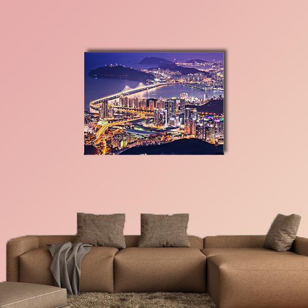 Busan Night Skyline with Illuminated Bridge Canvas Wall Art in gold, blue and purple, single panel hung on a wall