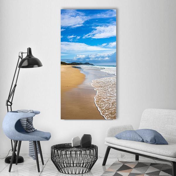Byron Bay Beach on a Summer Day Vertical Canvas Wall Art in white, beige and blue, single vertical panel hung on a wall