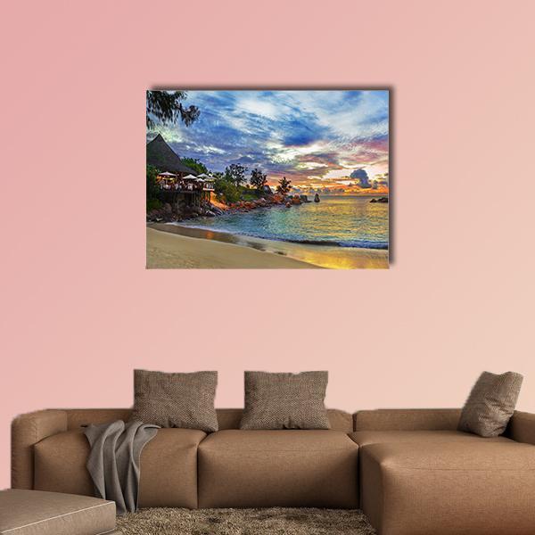 Sunset Cafe on Tropical Beach Canvas Wall Art in orange, yellow and blue, single panel hung on a wall