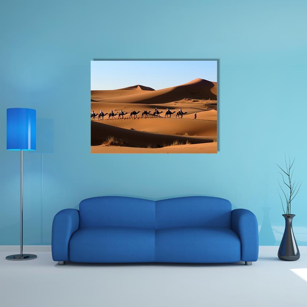 Camel Caravan in Sand Dunes Canvas Wall Art in brown, orange and blue, single panel hung on a wall