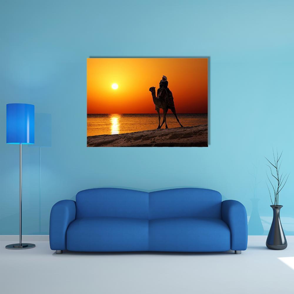 Camel and Rider Silhouette at Sunset Canvas Wall Art in black, orange and yellow, single panel hung on a wall