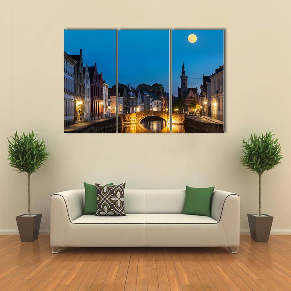 Canal in the Evening Canvas Wall Art in brown, yellow and blue, 3 panel horizontal set hung on a wall