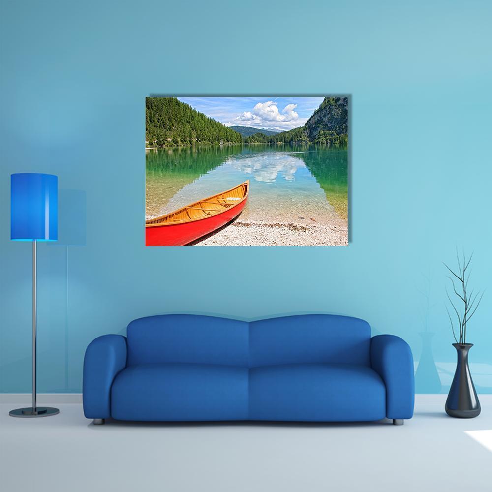 Red Canoe on Mountain Lake Canvas Wall Art in red, green and blue, single panel hung on a wall