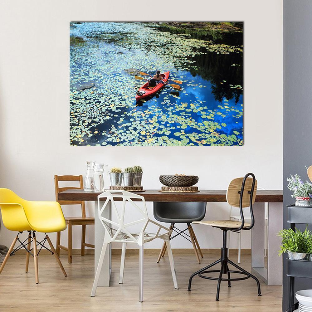 Kayaking Among Water Lilies Canvas Wall Art in red, green and blue, single panel hung on a wall