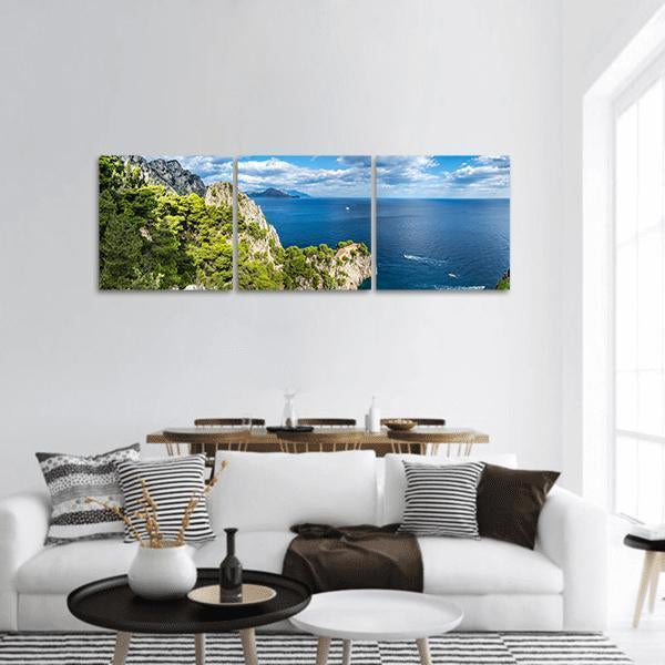 Capri Island Cliffs Over Deep Blue Sea Panoramic Canvas Wall Art in green and blue, hung on a wall