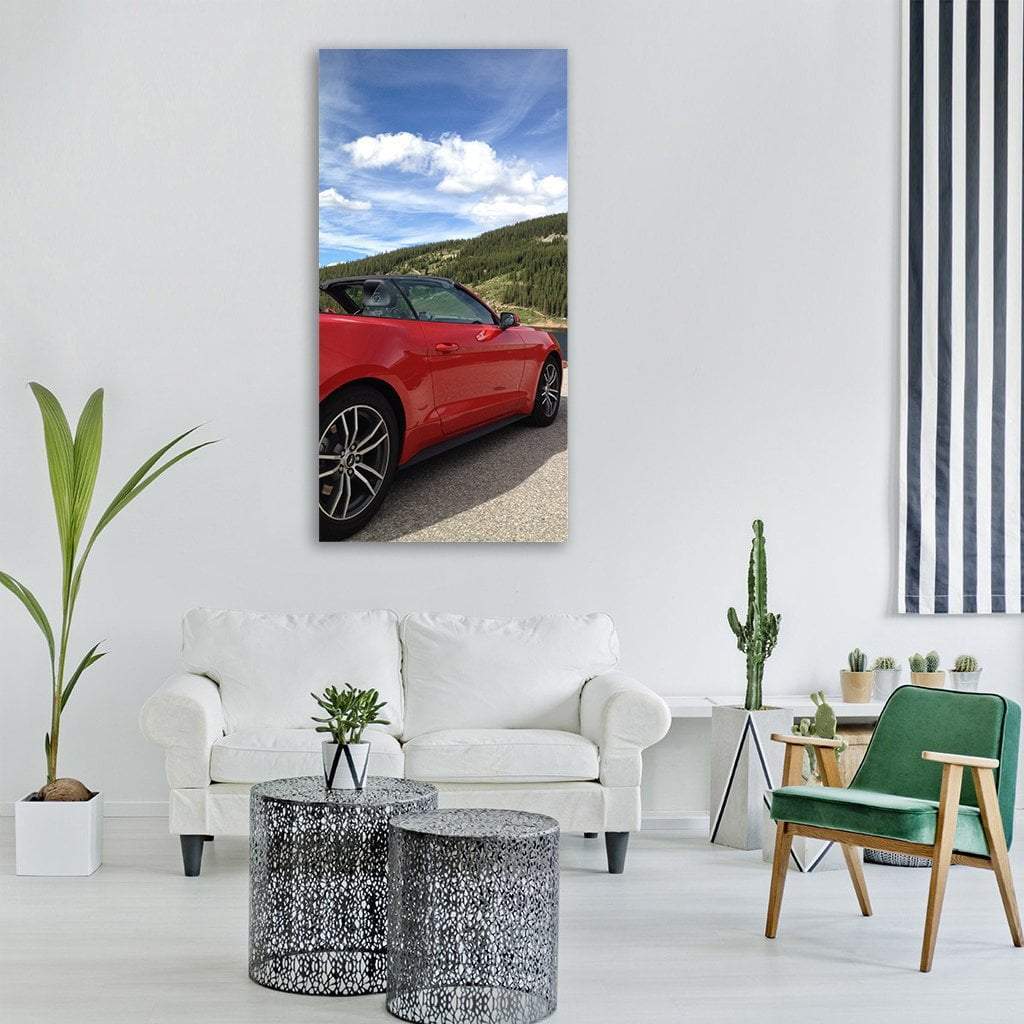 Red Mustang Convertible on Mountain Road Vertical Canvas Wall Art in red, green and blue, single vertical panel hung on a wall