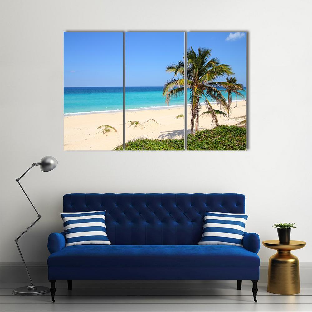 Tropical Cuban Beach with Palm Trees Canvas Wall Art in beige, green and blue, 3 panel horizontal set hung on a wall