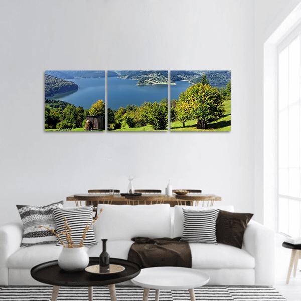 Carpathian Lake with Wooden Shed Panoramic Canvas Wall Art in green and blue, hung on a wall