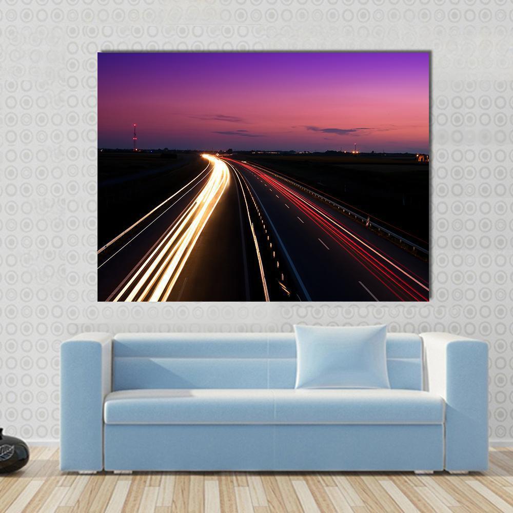 Cars Speeding on Highway Canvas Wall Art in black, orange and purple, single panel hung on a wall