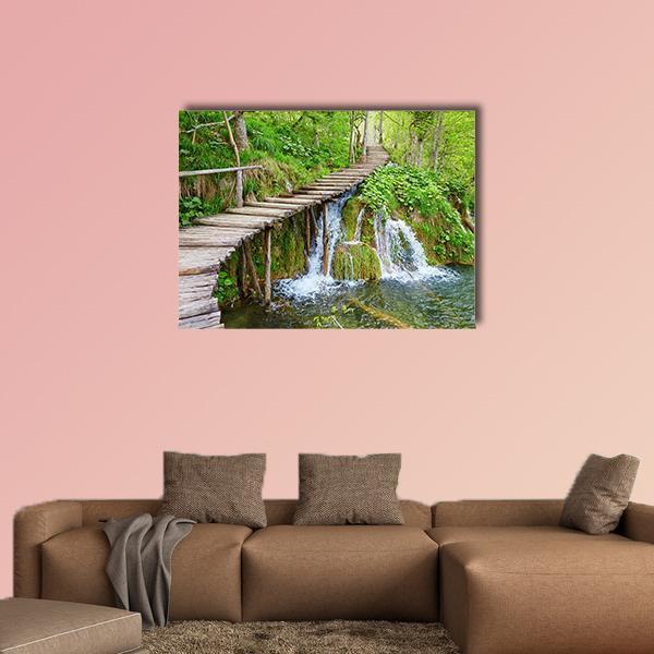 Plitvice Lake Boardwalk Path Canvas Wall Art in brown, green and blue, single panel hung on a wall