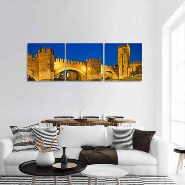 Castelvecchio Bridge at Twilight Panoramic Canvas Wall Art in brown, yellow and blue, hung on a wall